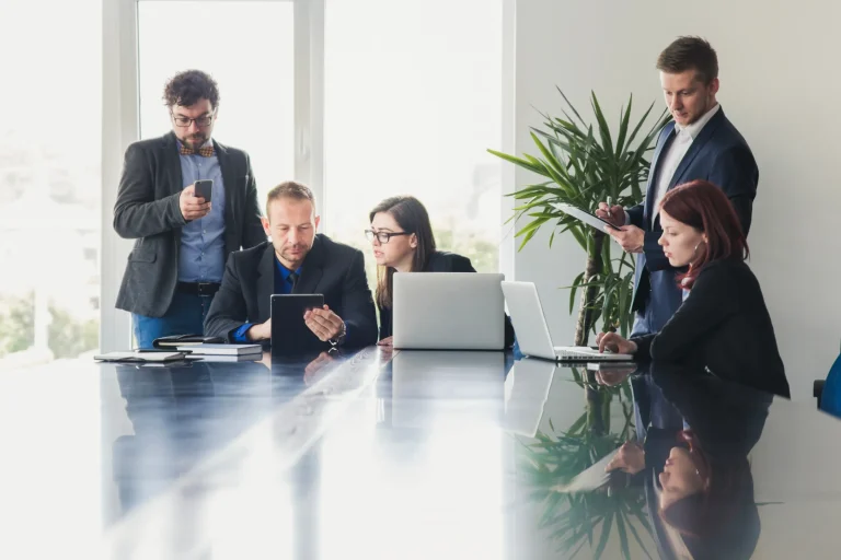 Business team meeting around a glass table with laptops